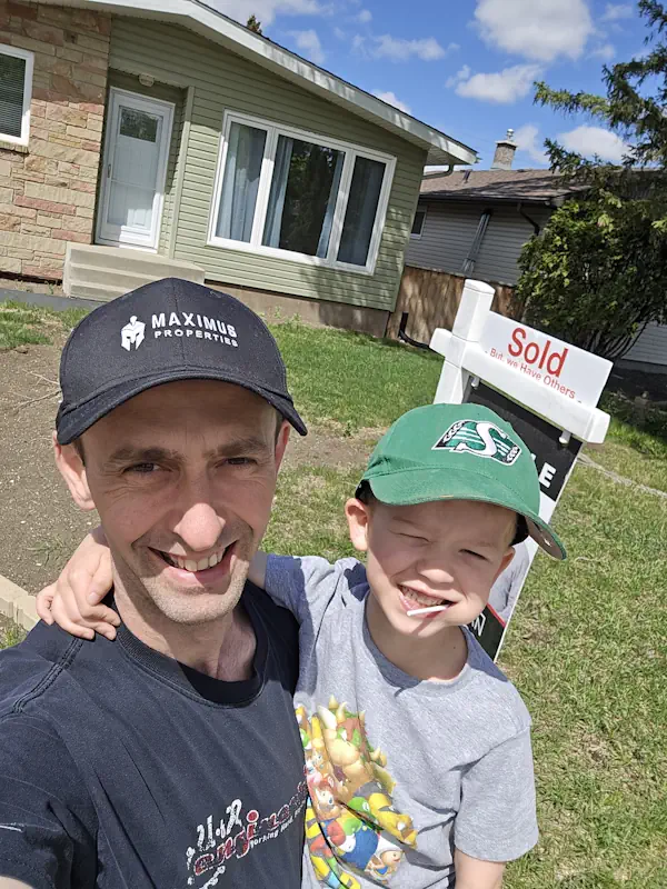 Dave Shymko of Maximus Properties standing with his son in front of a Regina bungalow he bought